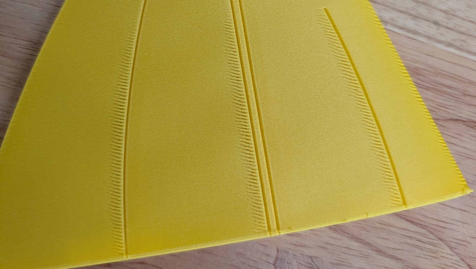 A yellow lightweight-PLA 3D-printed panel with ribbed lines across its surface