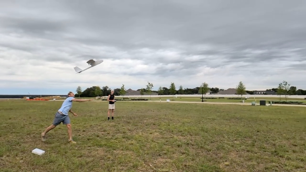 Launch video: a member throws the plane while the pilot stands by with the transmitter