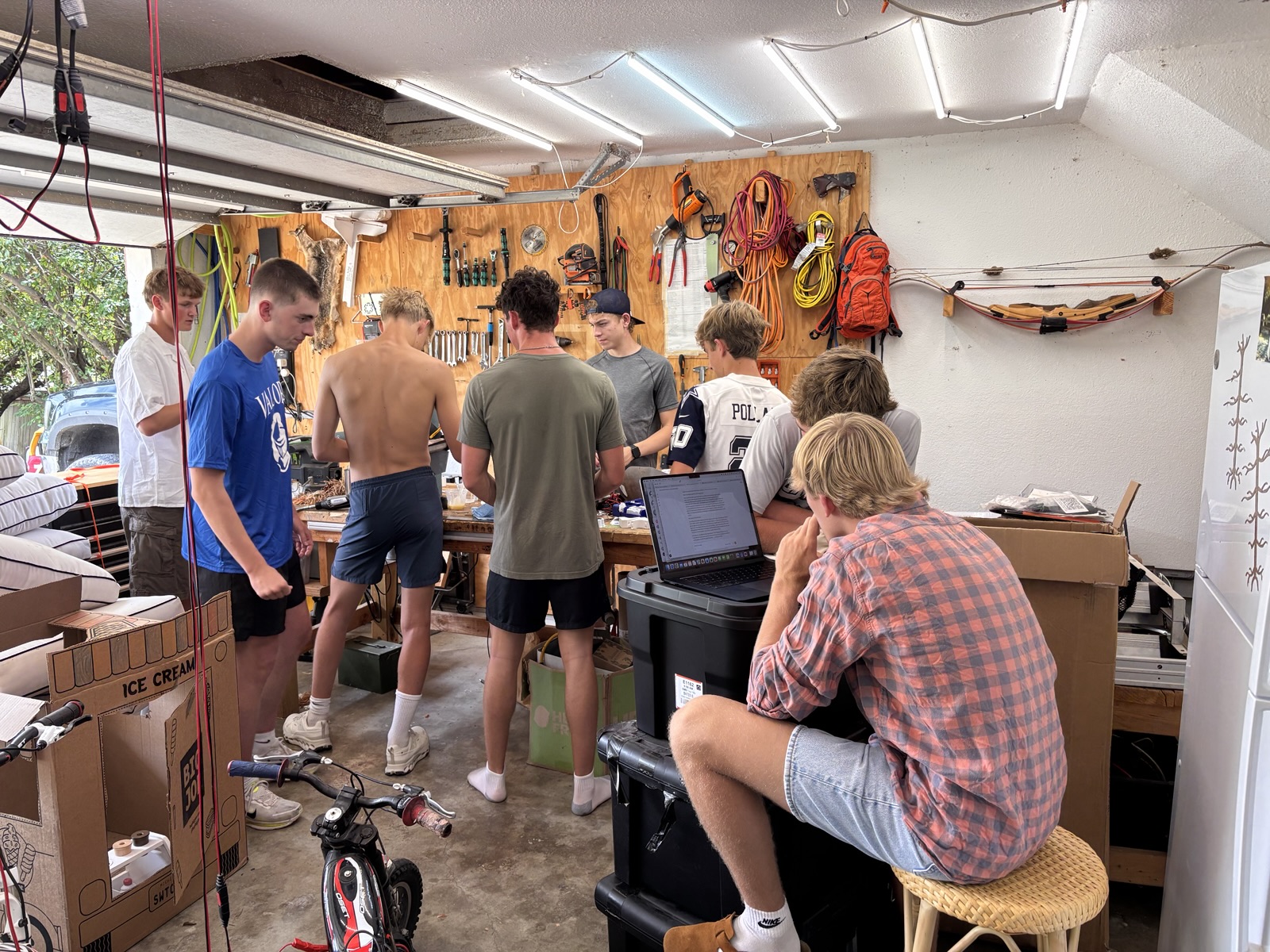 Club members gathered around the workbench in the garage shop