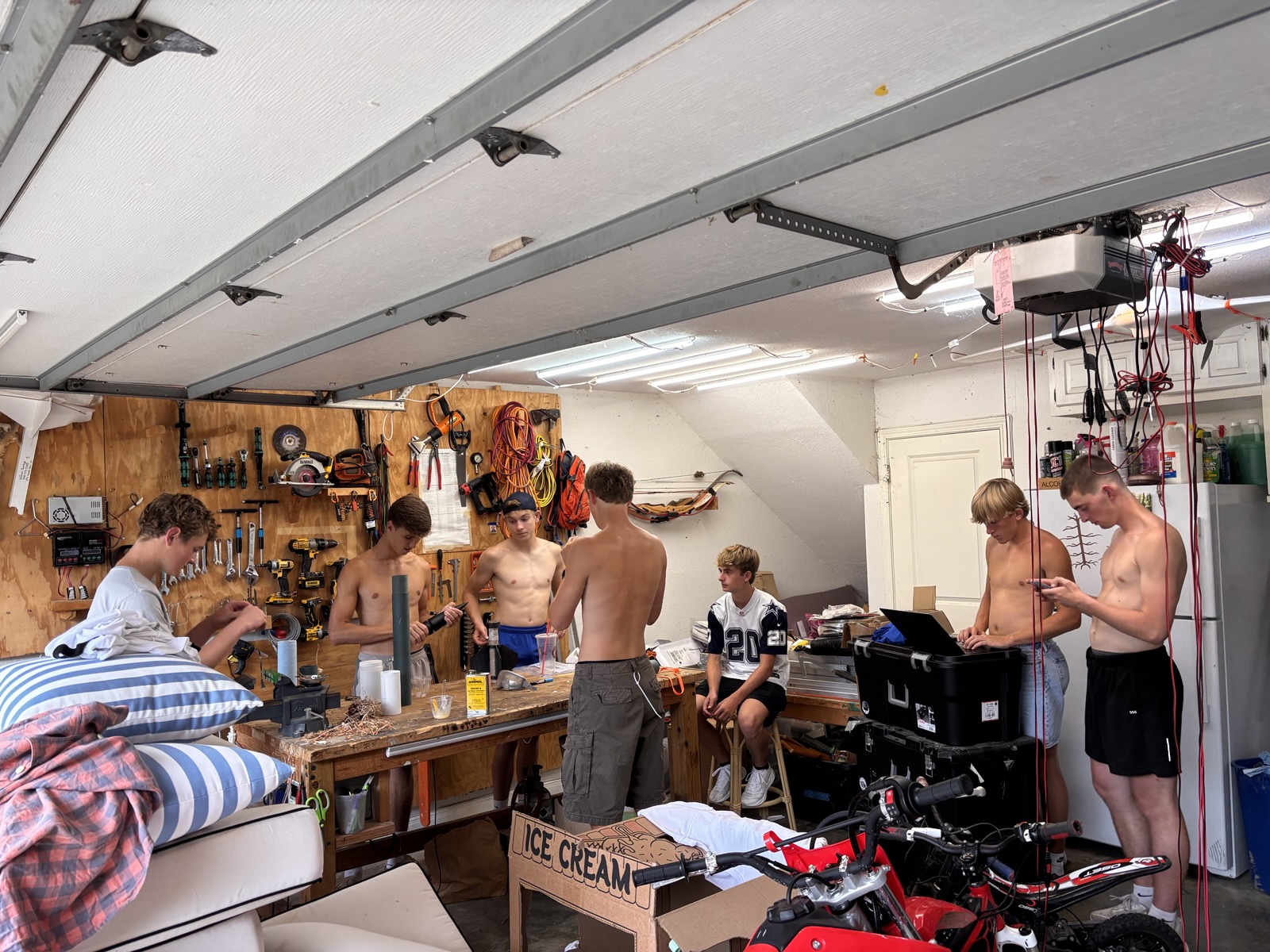 Club members working in the garage with a laptop on a toolbox